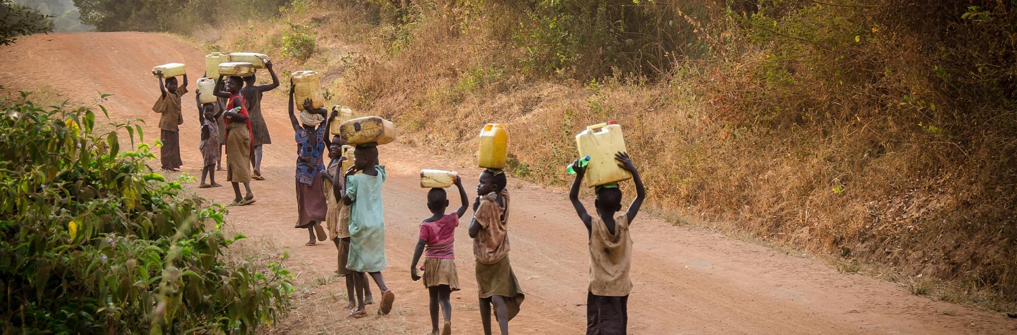 children walking along a path in uganda
